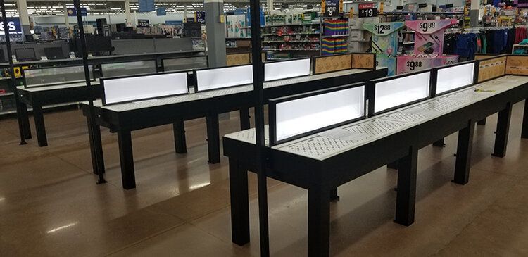 A row of tables in a store with lights on them.