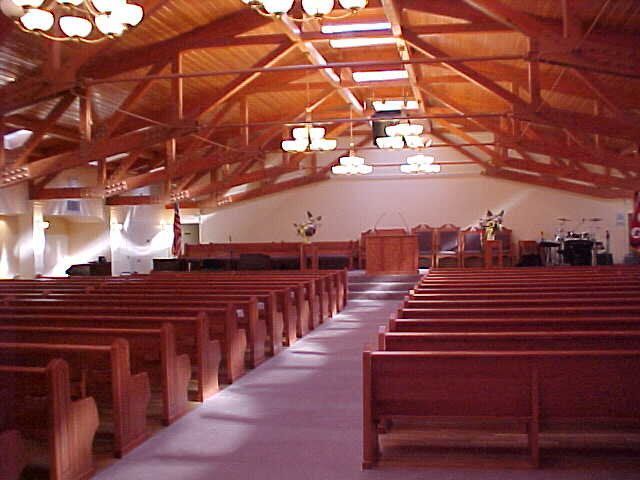 The inside of a church with rows of wooden benches