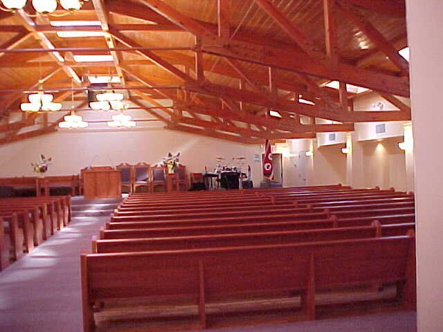 The inside of a church with rows of wooden benches