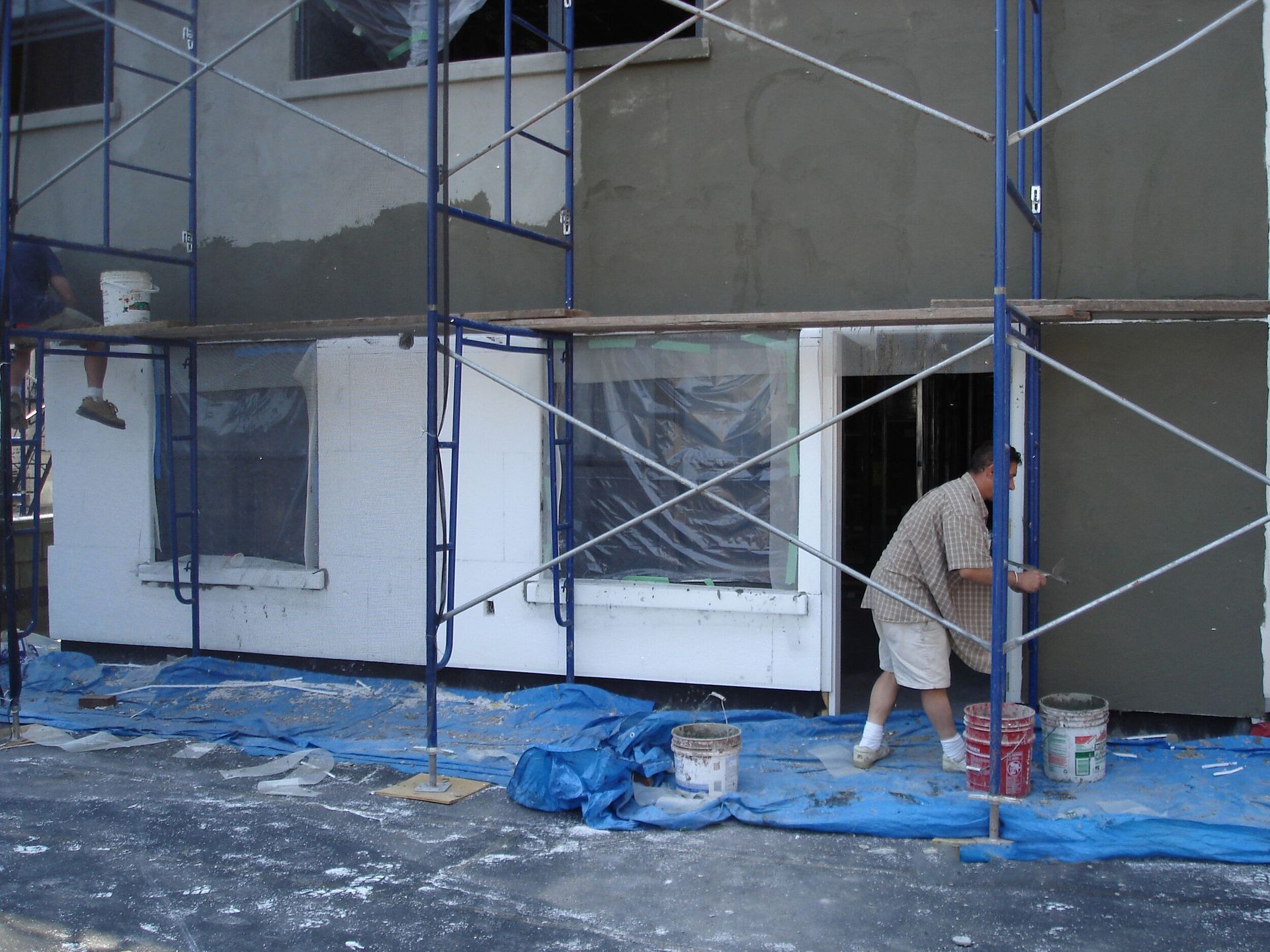 A man is working on a building with scaffolding around it