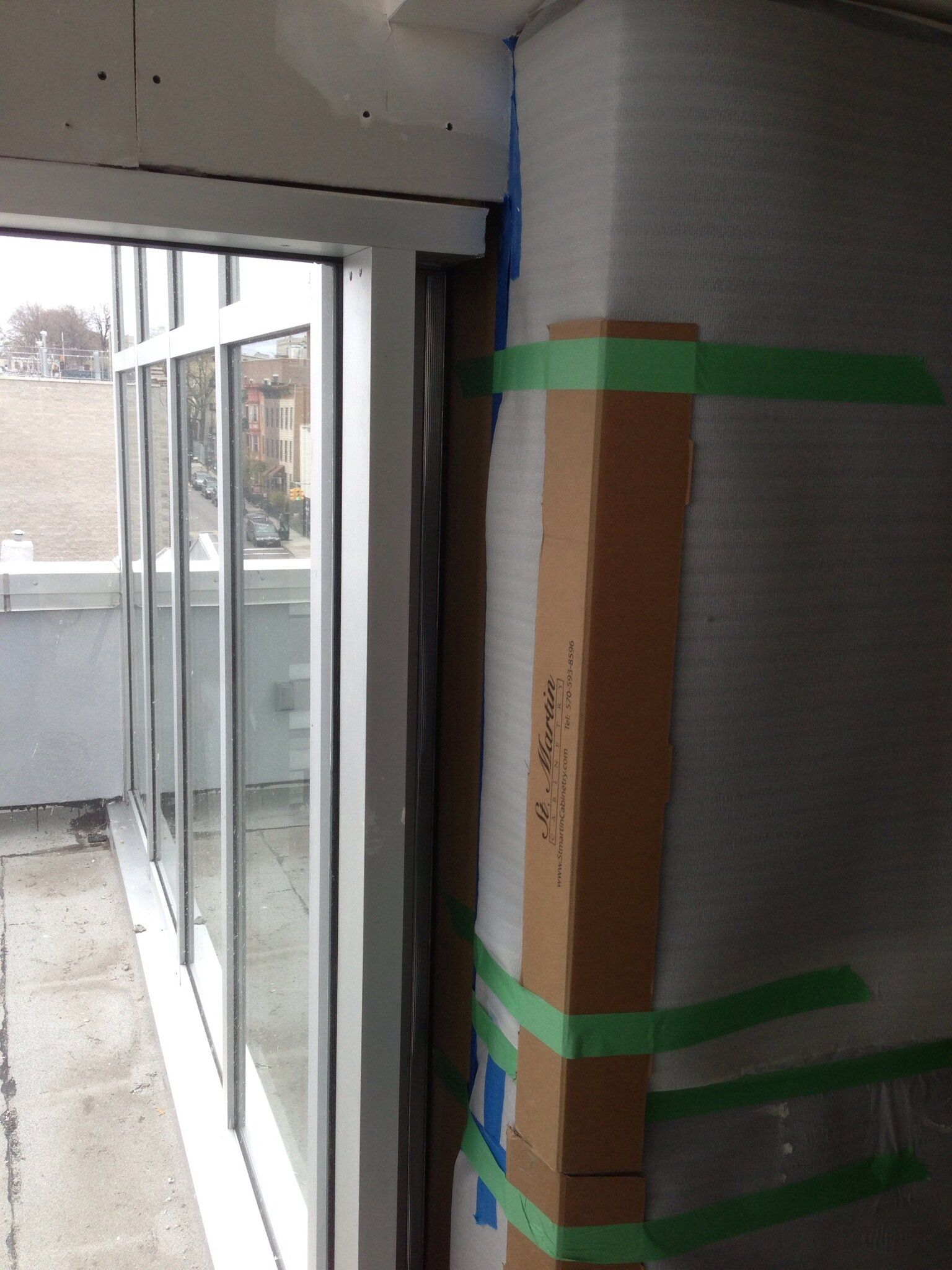 A corner of a building with a cardboard box taped to it