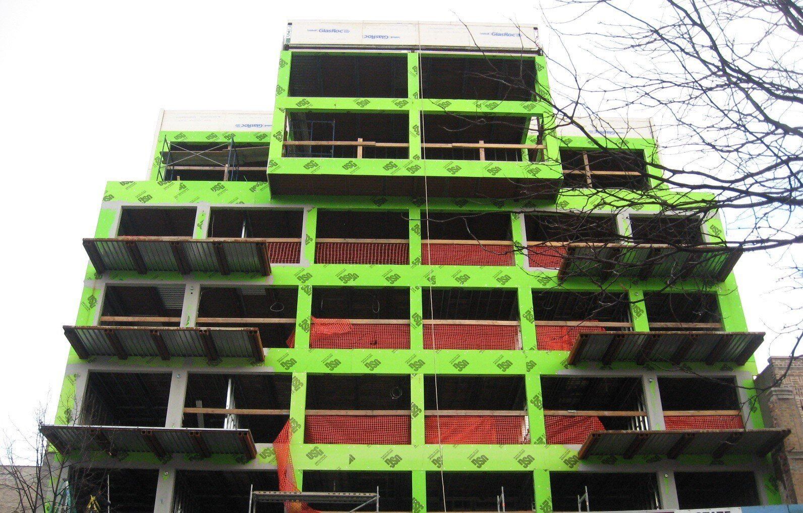 A green building with a lot of windows under construction