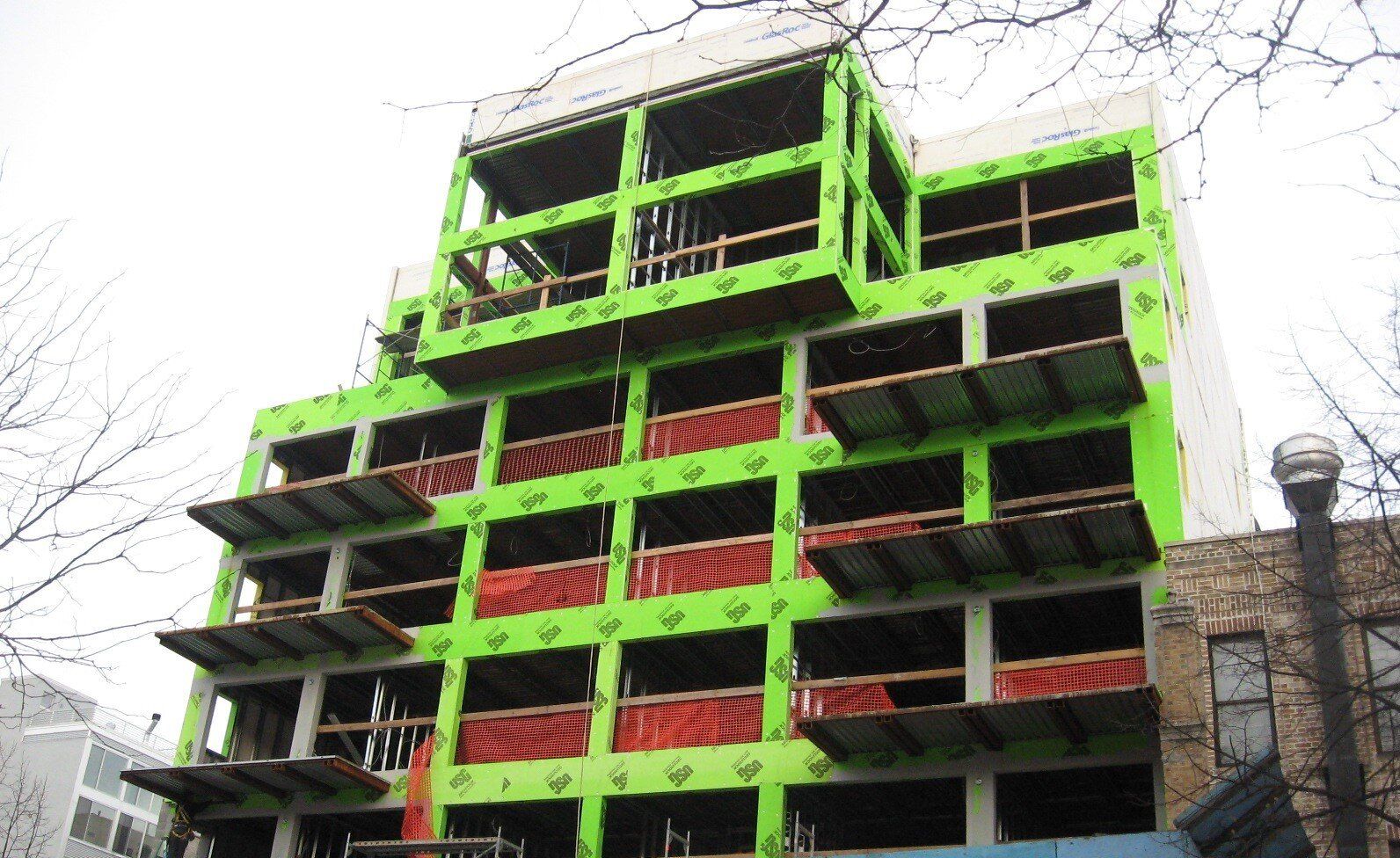 A green building under construction with a lot of windows