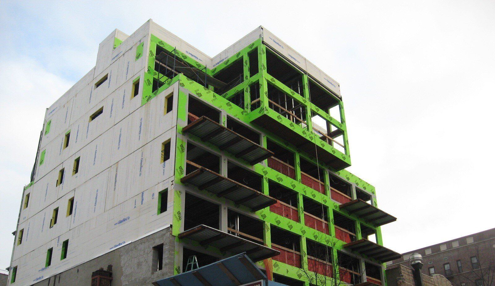 A large building under construction with green walls