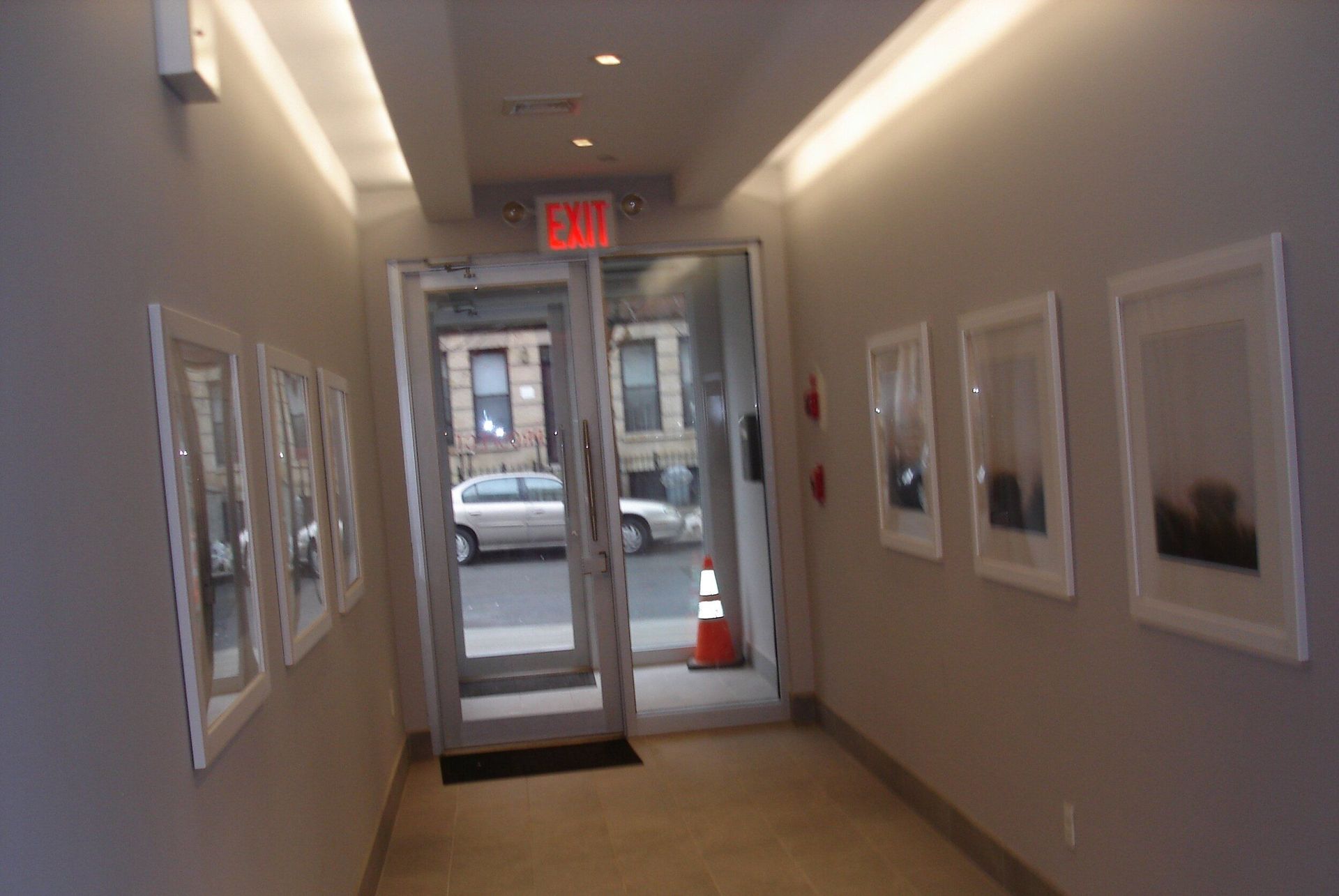 A hallway with a red exit sign above the door