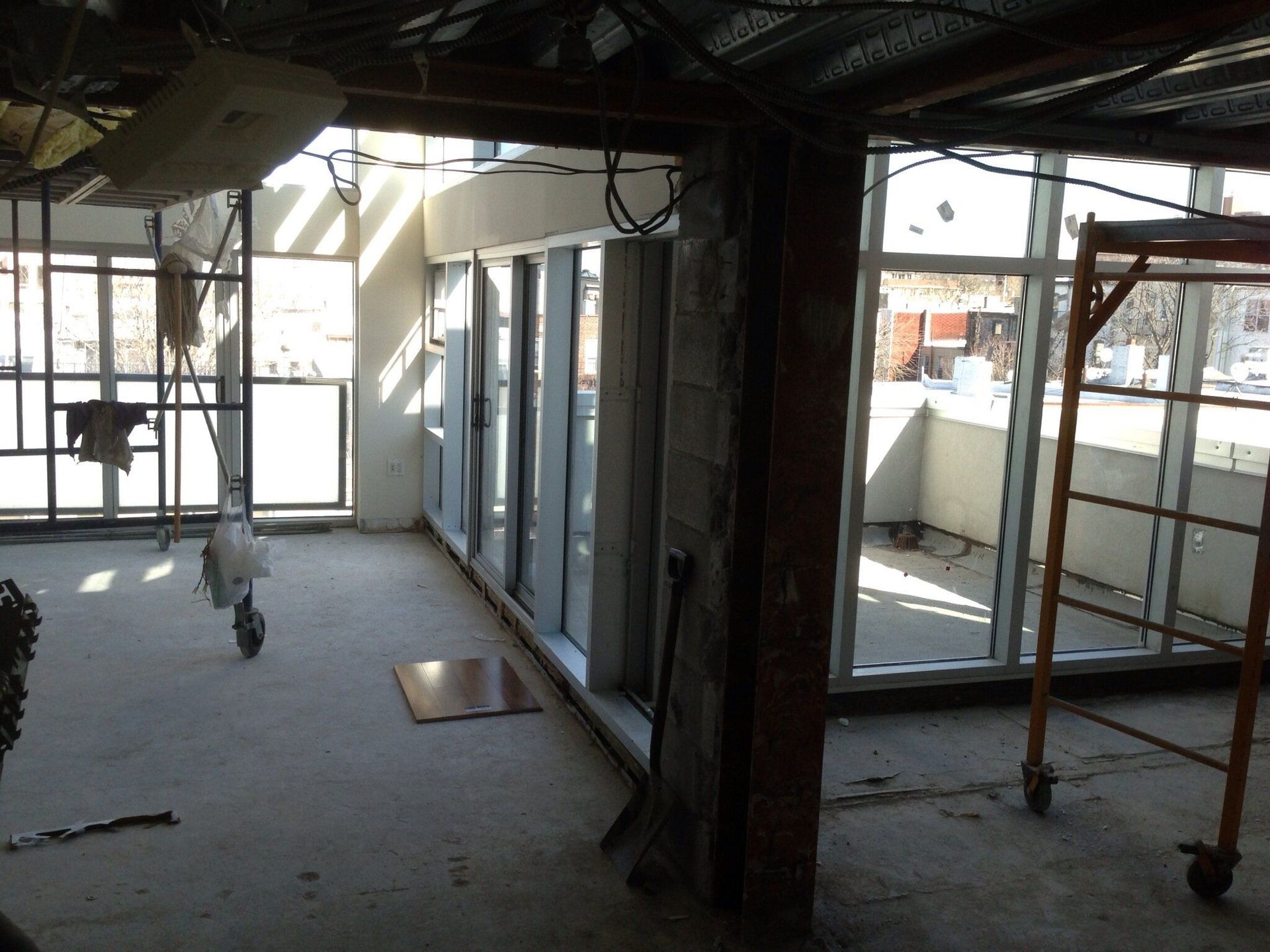 An empty room with a lot of windows and scaffolding