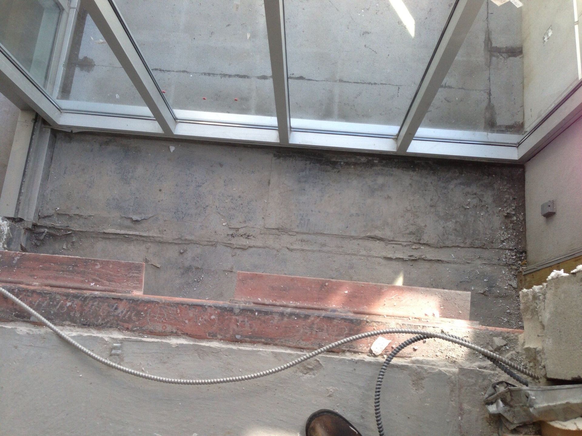 A person is working on a concrete floor next to a window