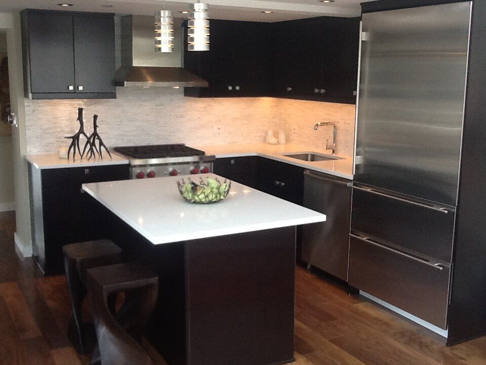 A kitchen with black cabinets and stainless steel appliances