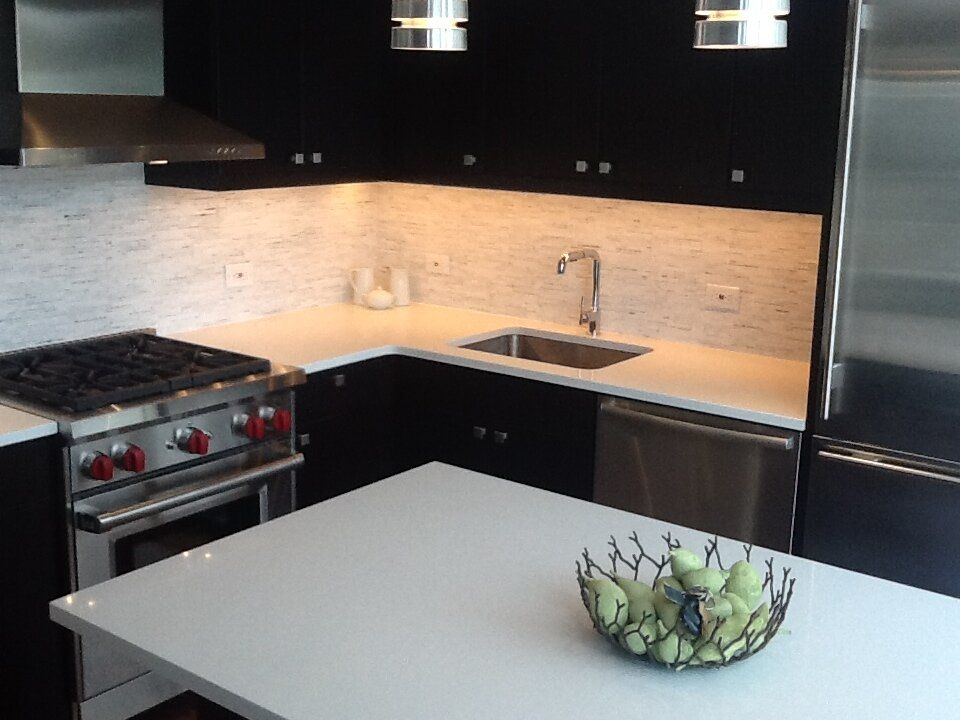 A kitchen with stainless steel appliances and black cabinets