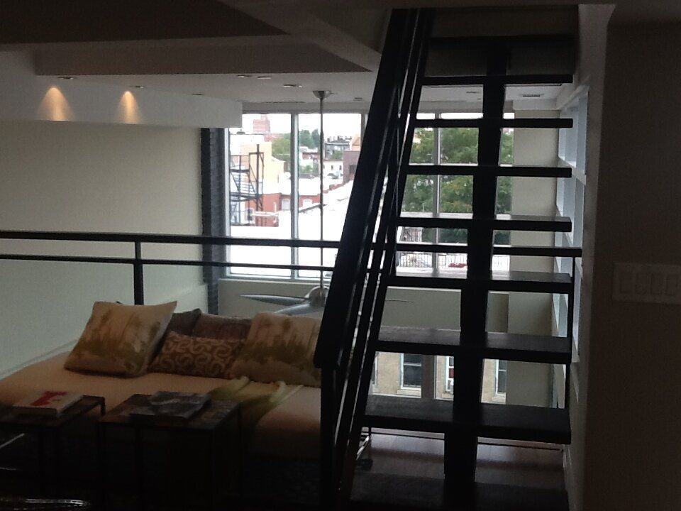 A living room with stairs leading up to the second floor