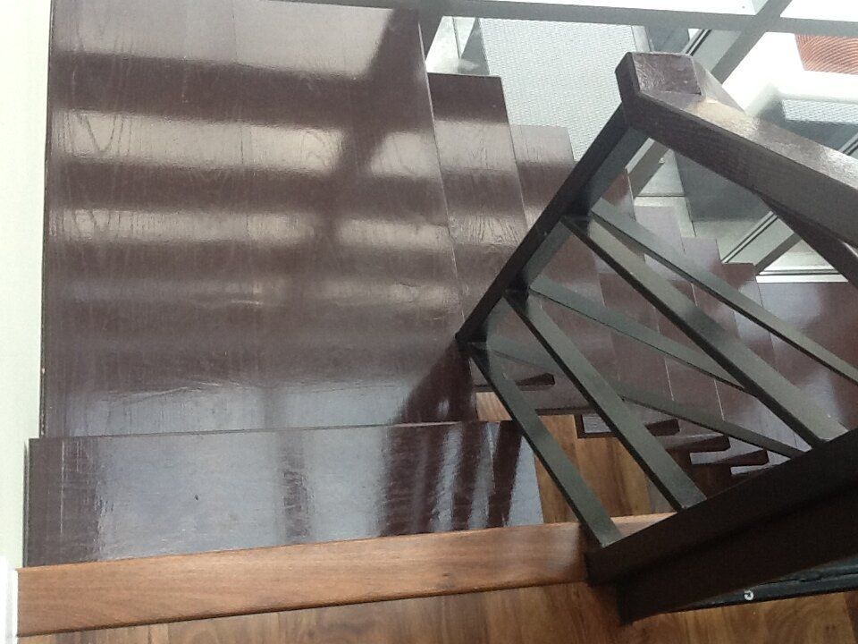 A wooden staircase with a metal railing and a glass railing