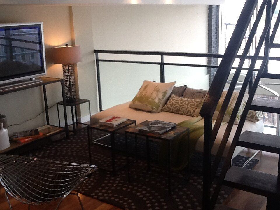 A living room with a couch and stairs leading up to the second floor