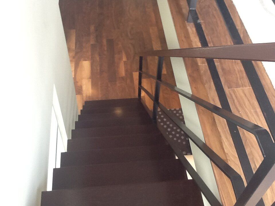 A staircase with a wooden floor and a metal railing