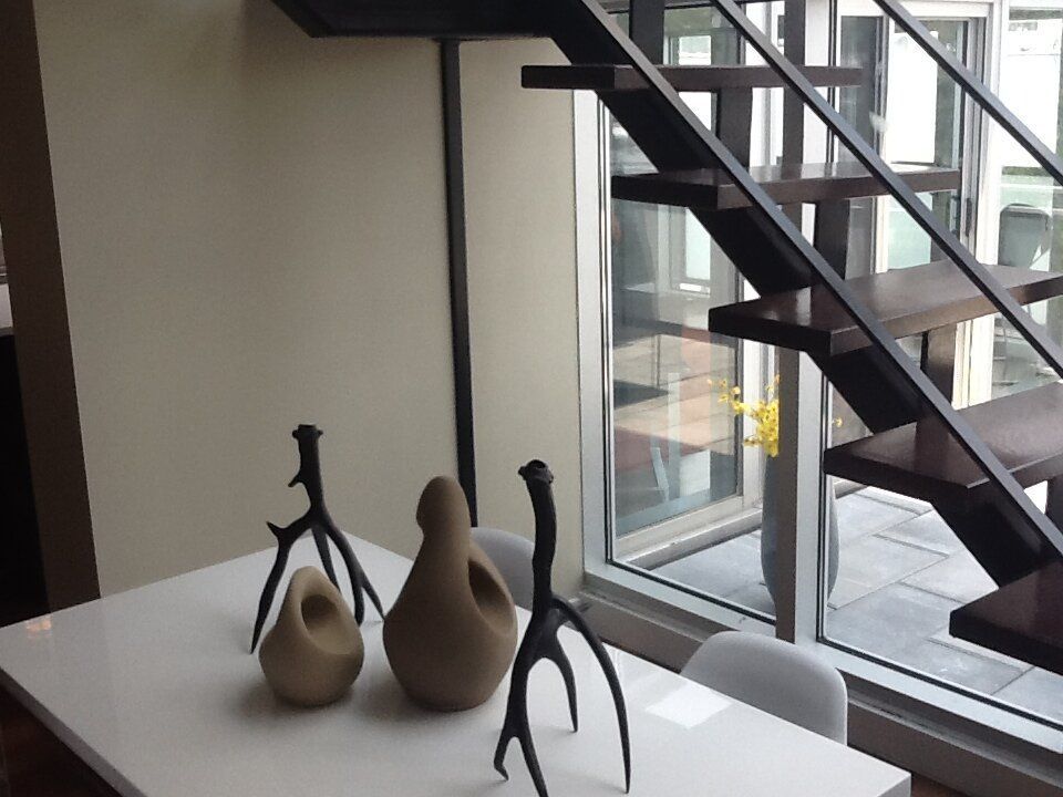 A table with three vases on it in front of a staircase