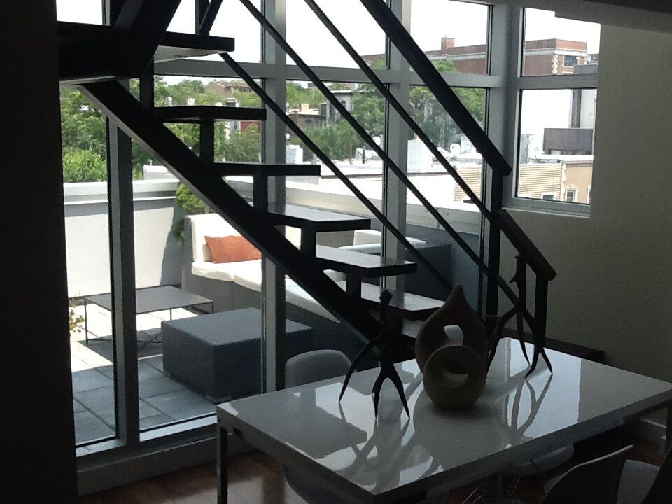 A dining room with a staircase leading up to the second floor