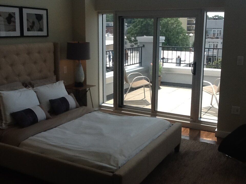 A bedroom with a sliding glass door that leads to a balcony