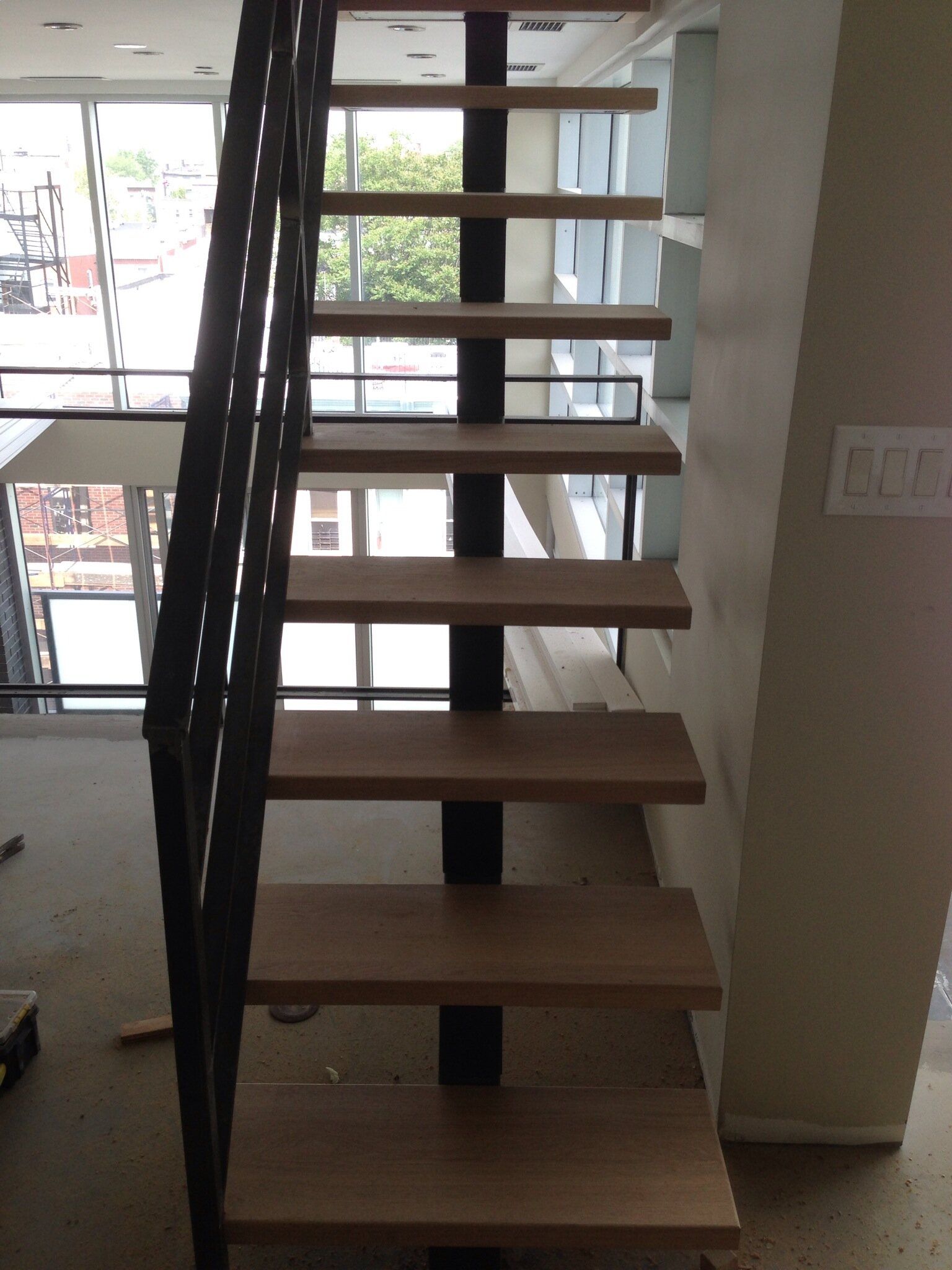A staircase with wooden steps and a black railing