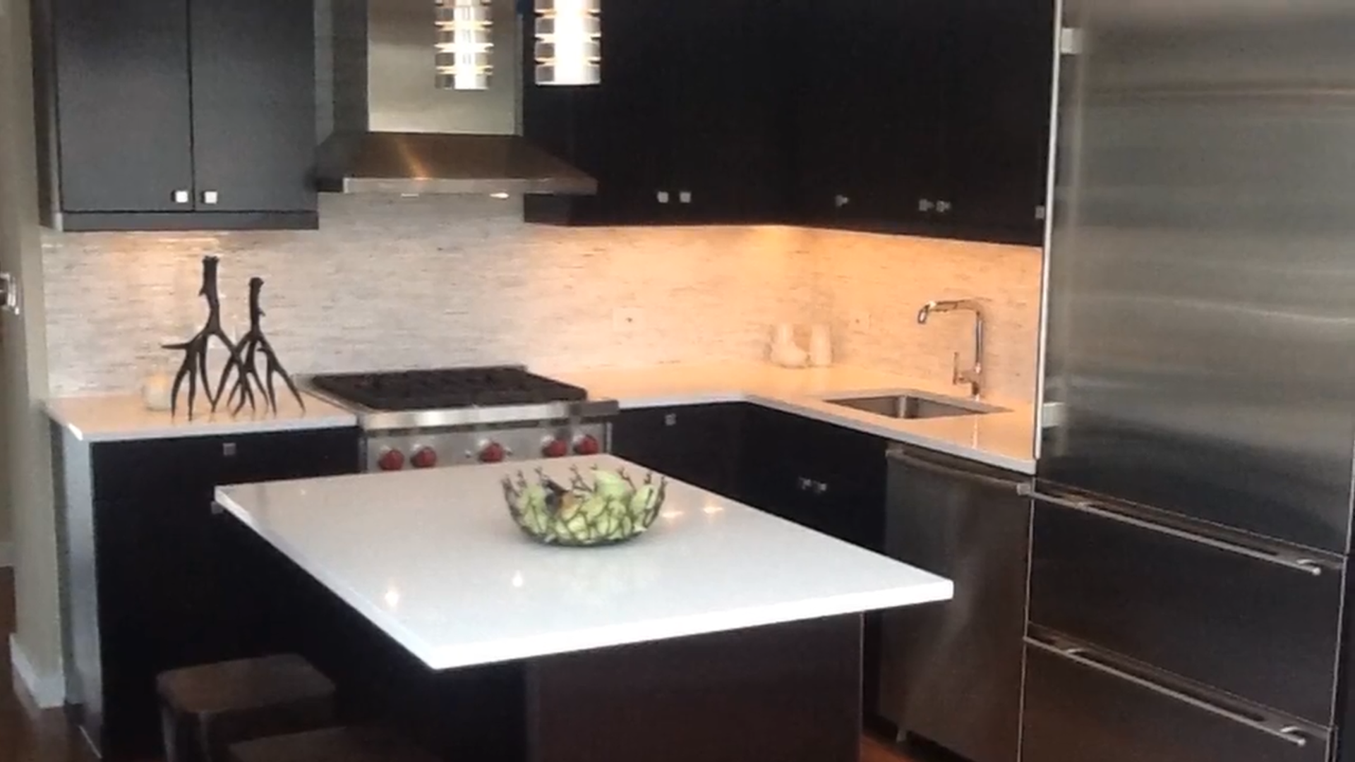 A kitchen with black cabinets and stainless steel appliances