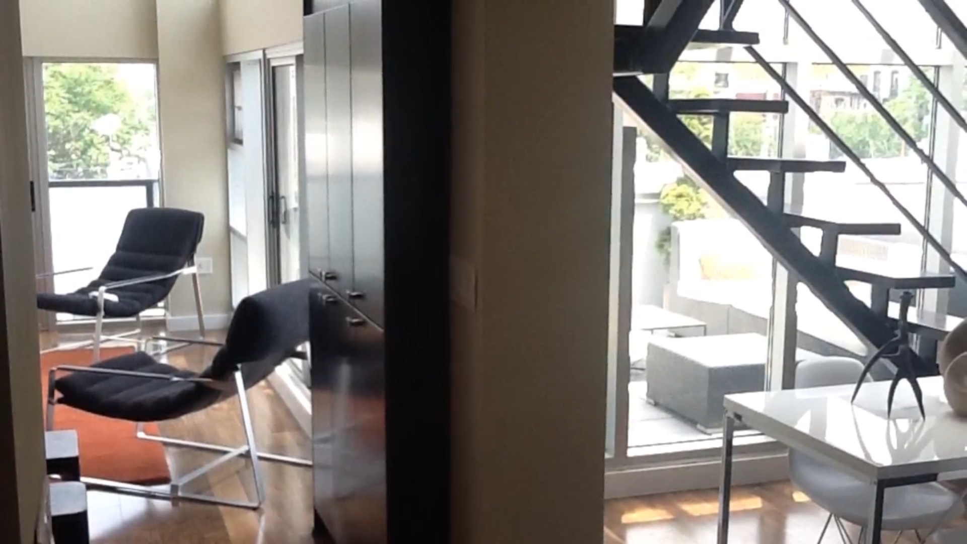 A living room with a staircase leading up to the second floor