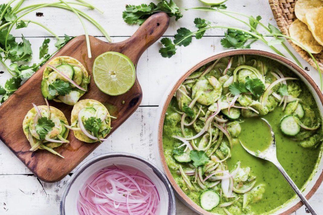 A table topped with bowls of food and a wooden cutting board.