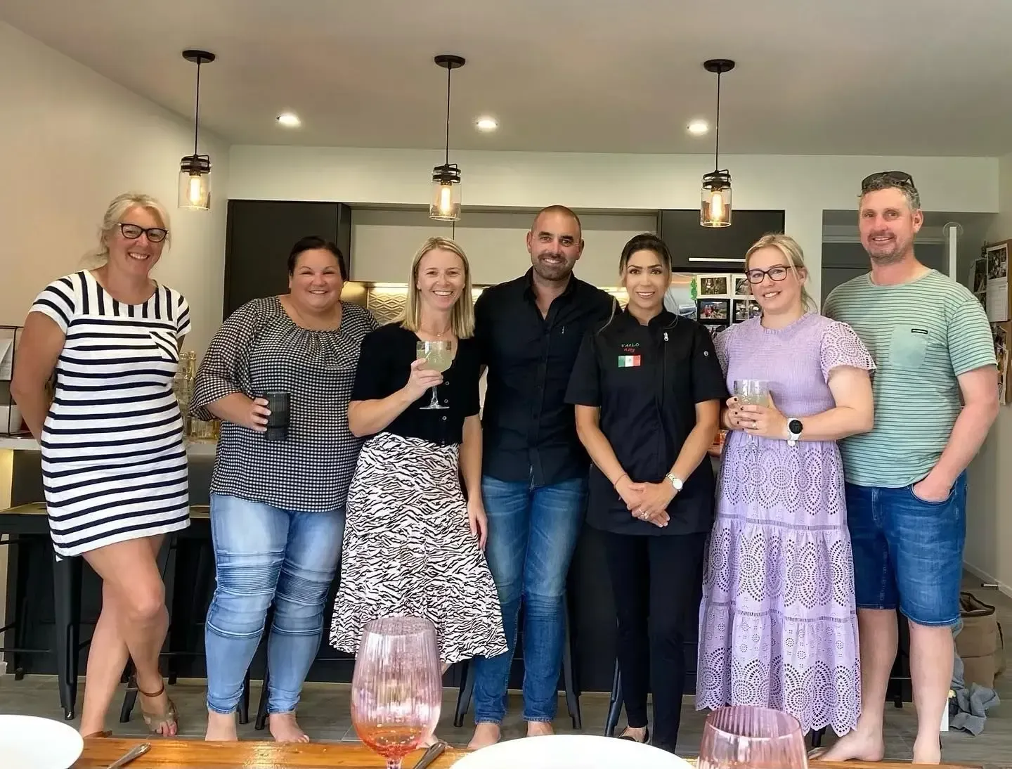 A group of people are posing for a picture in a kitchen.