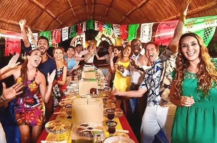 A group of people are standing around a long table.