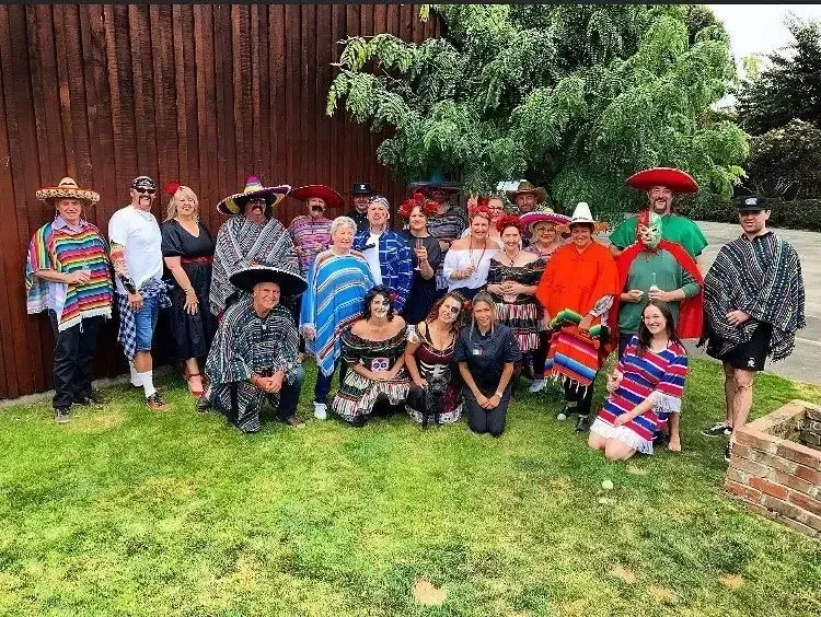 A group of people dressed in mexican costumes are posing for a picture.
