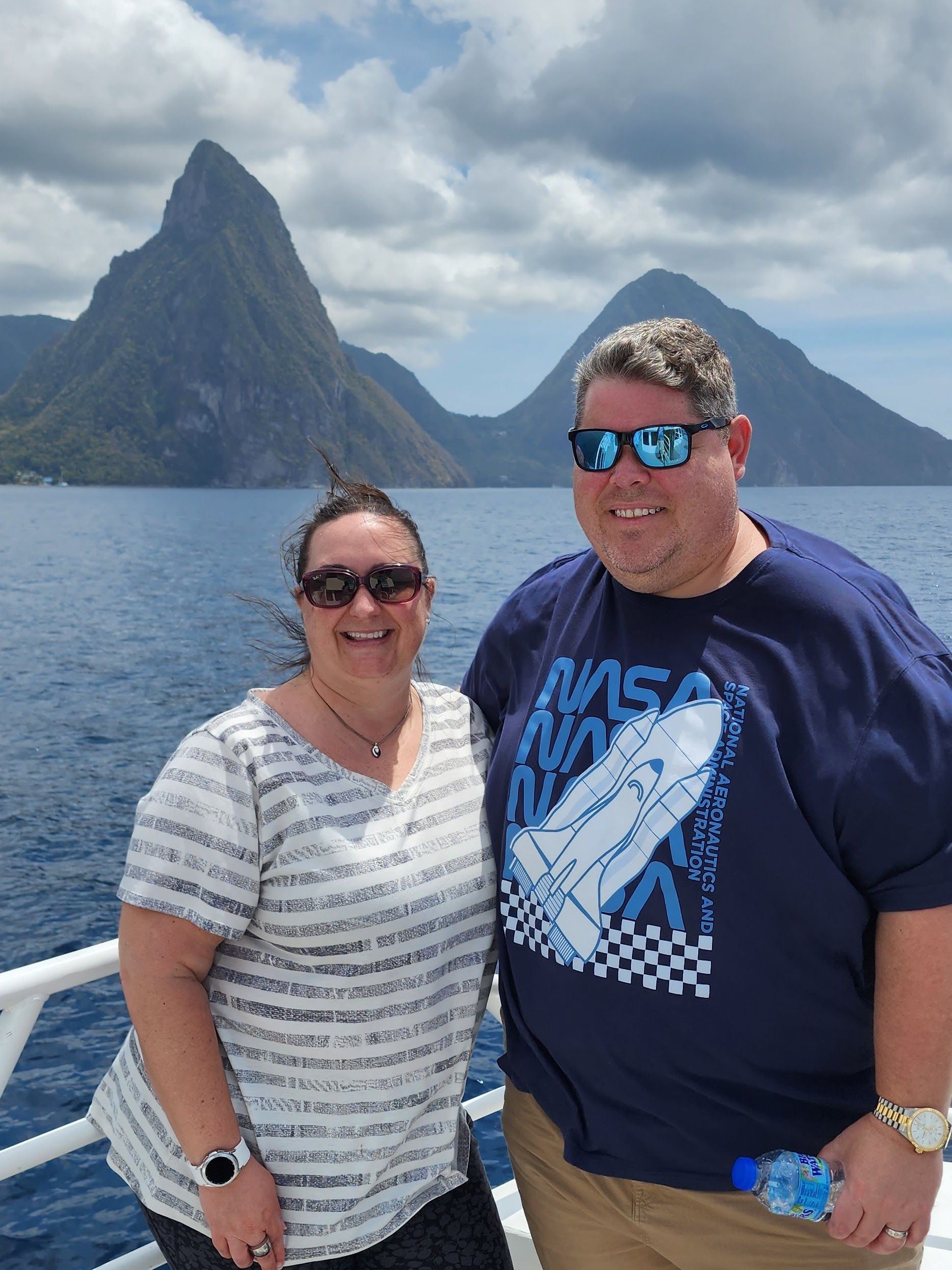 a man and a woman are posing for a picture and smiling for the camera .