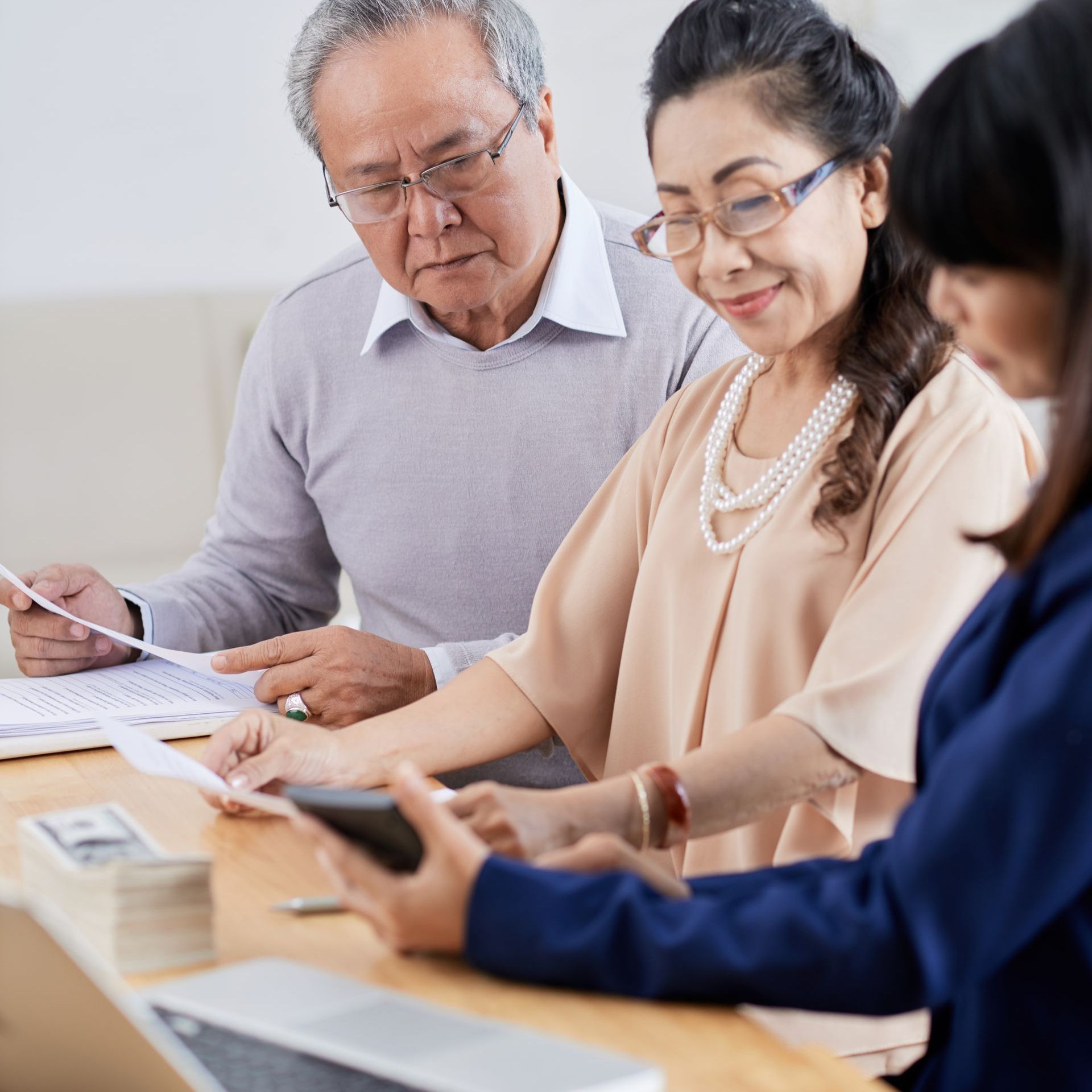 a group of people are sitting at a table looking at papers
