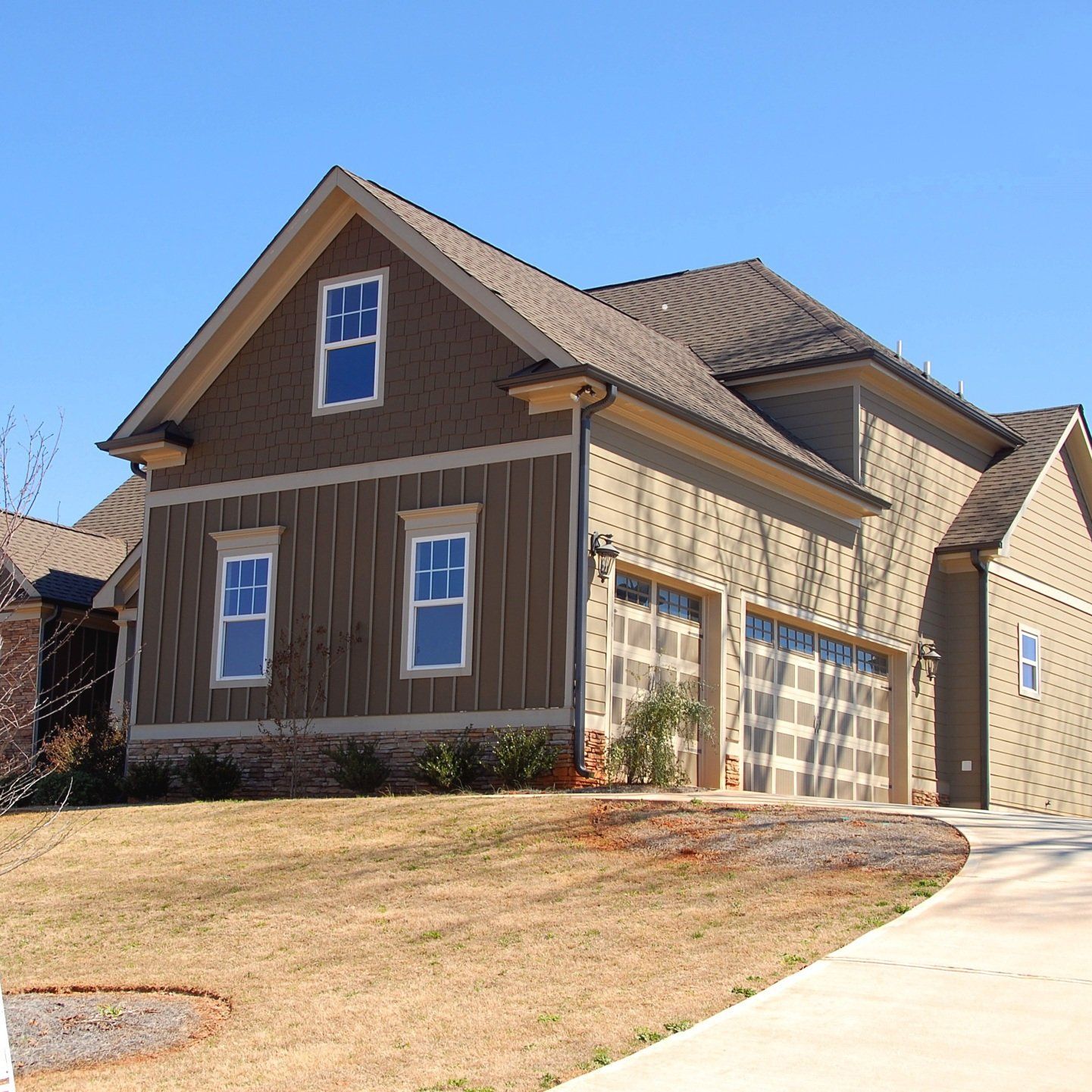 a house with a lot of windows and garage doors