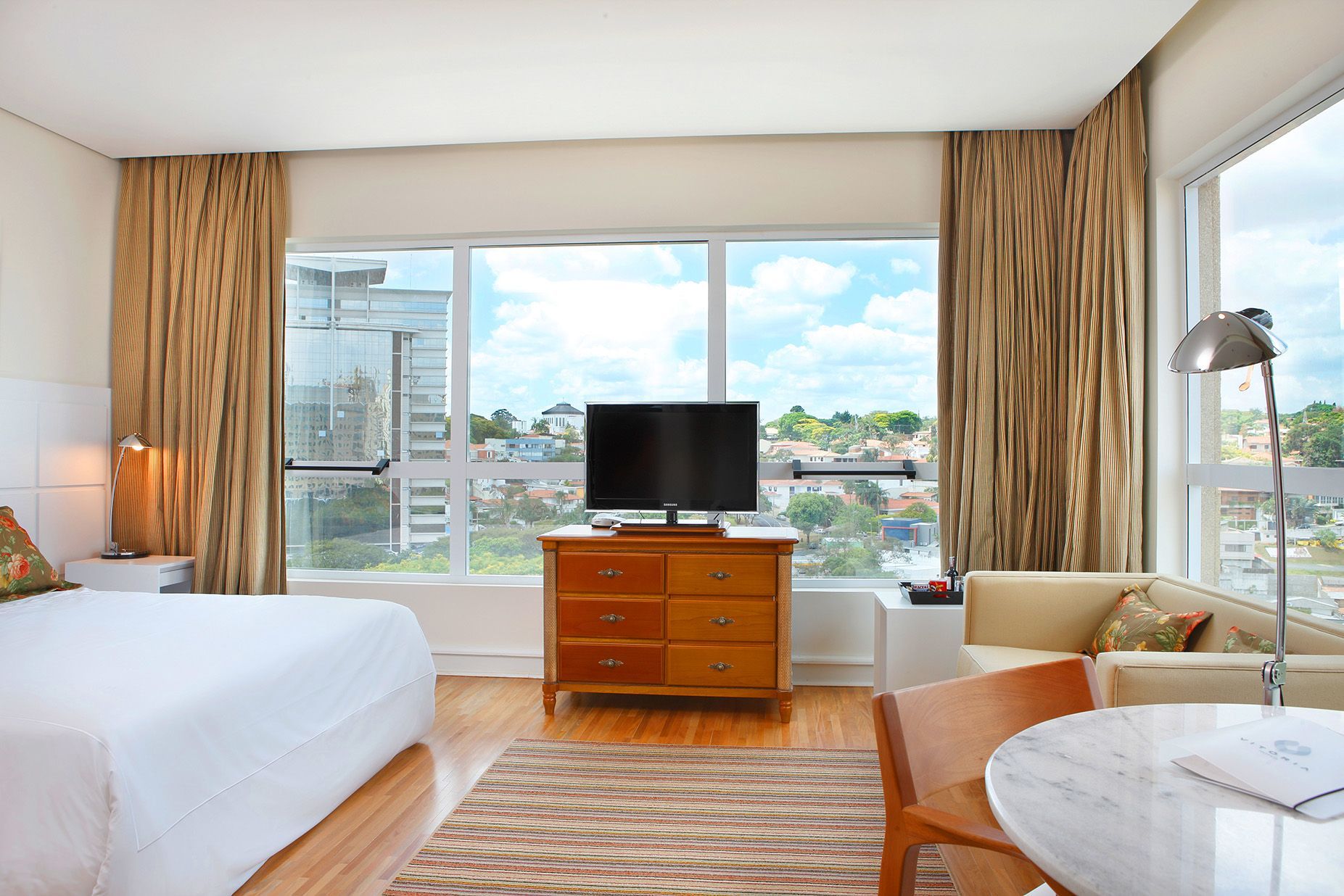 Um quarto de hotel com uma cama king size e uma TV de tela plana