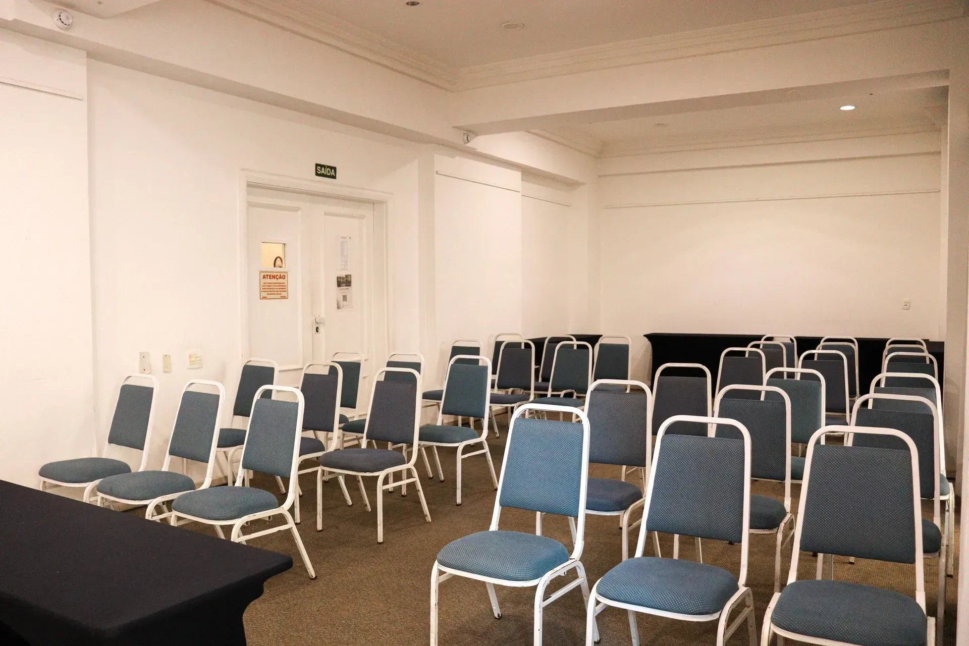 Uma sala de conferências com cadeiras azuis e uma mesa preta