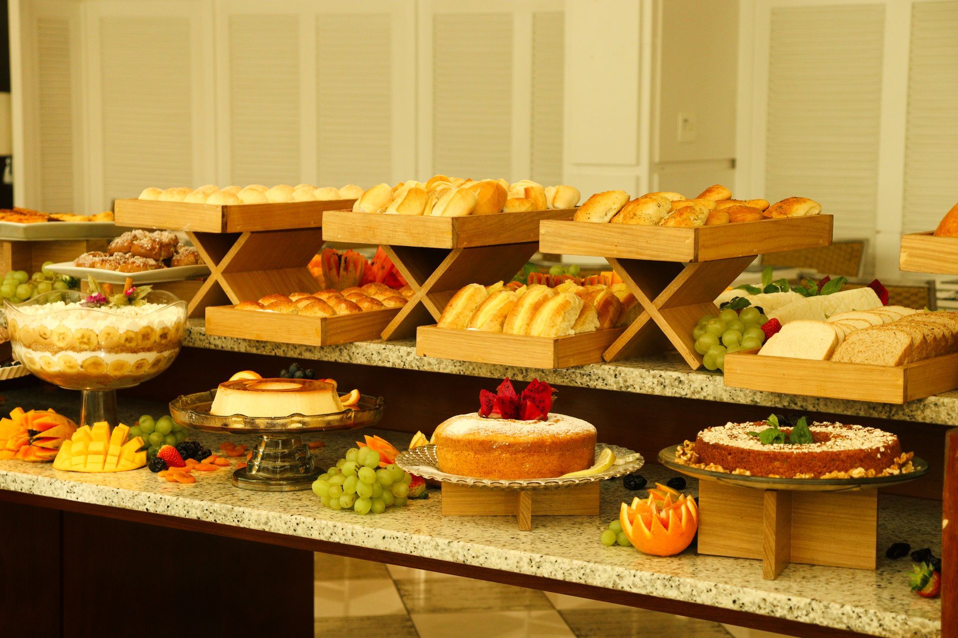 Uma mesa de bufê com uma variedade de sobremesas e pães