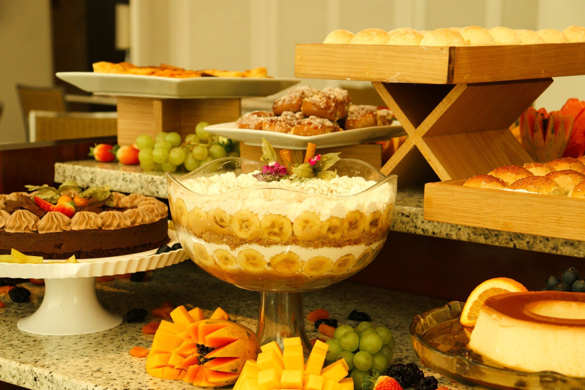 Uma mesa coberta com uma variedade de sobremesas, incluindo um trifle de banana