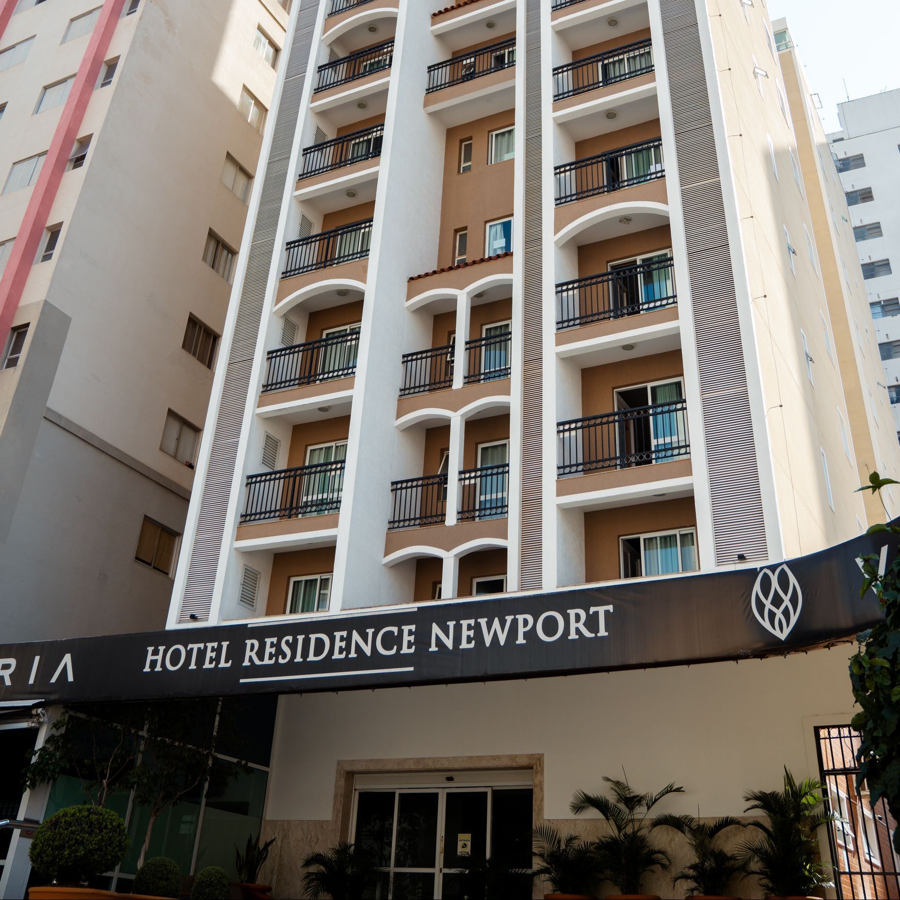 Edifício de apartamentos Hotel Residence Newport com varandas e toldo escuro na entrada.