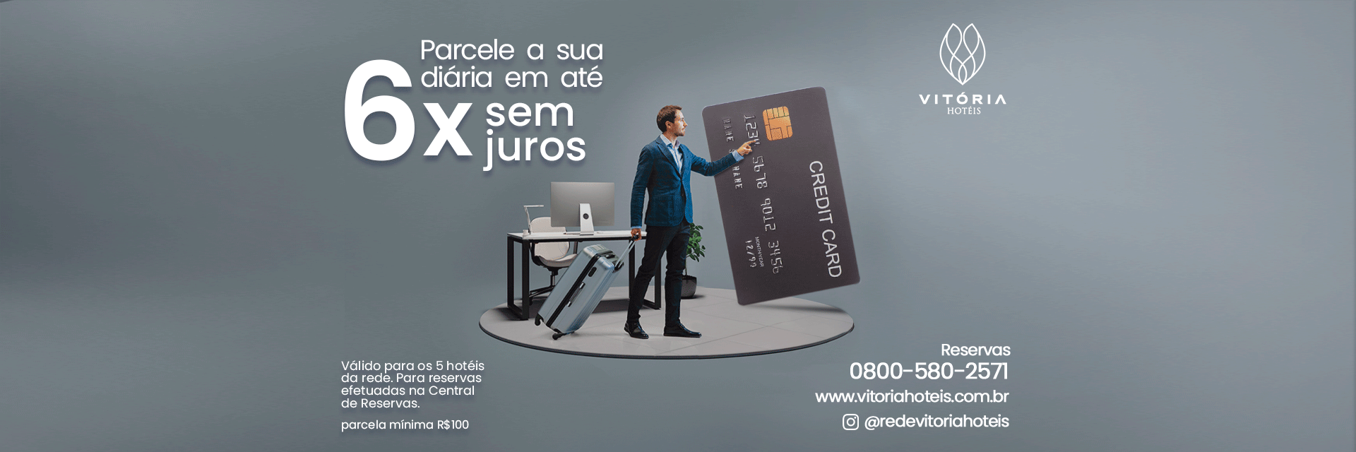 Homem em pé ao lado de um painel publicitário preto em um palco cinza, com grandes letras brancas que dizem “6x” e “24 meses”.