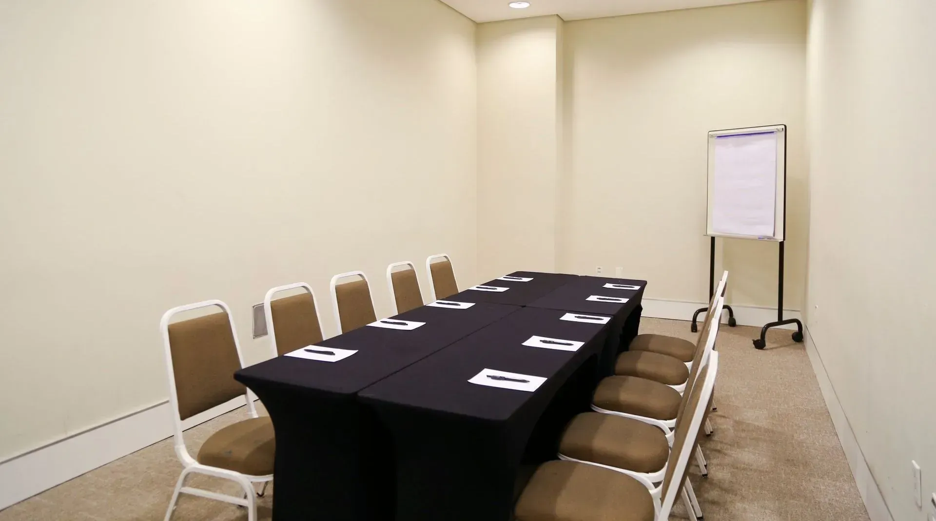 Uma sala de conferências com uma mesa longa e cadeiras.
