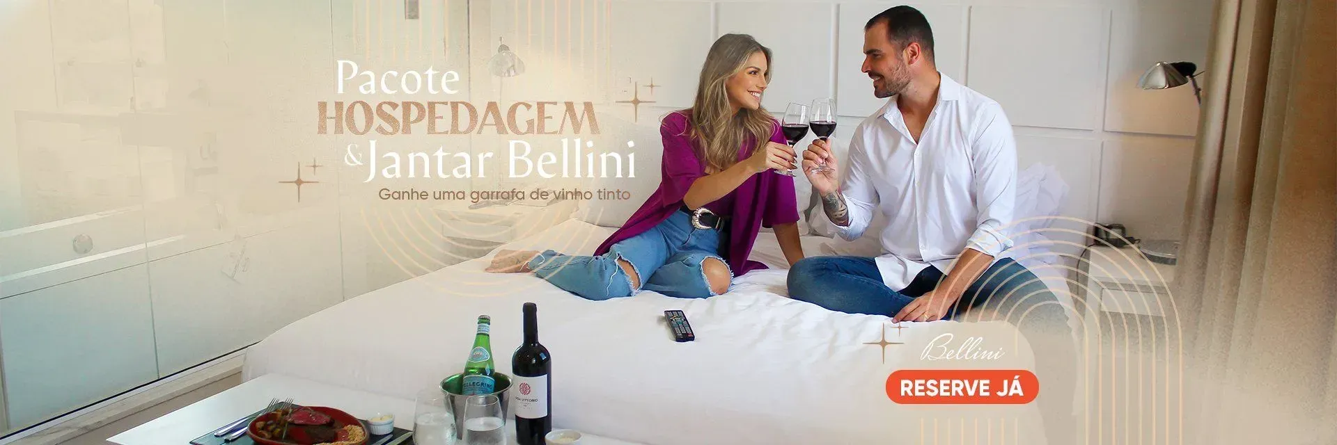 Um homem e uma mulher estão sentados em uma cama bebendo vinho.