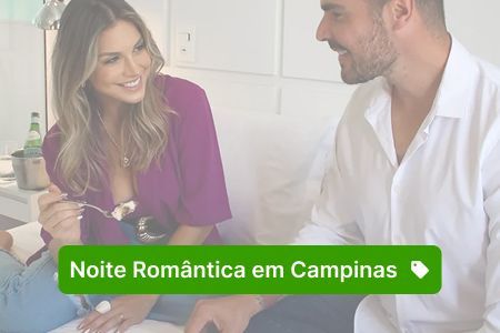 Um casal aproveita uma noite romântica em Campinas. A mulher, de blusa roxa, come a sobremesa enquanto sorri para o homem.
