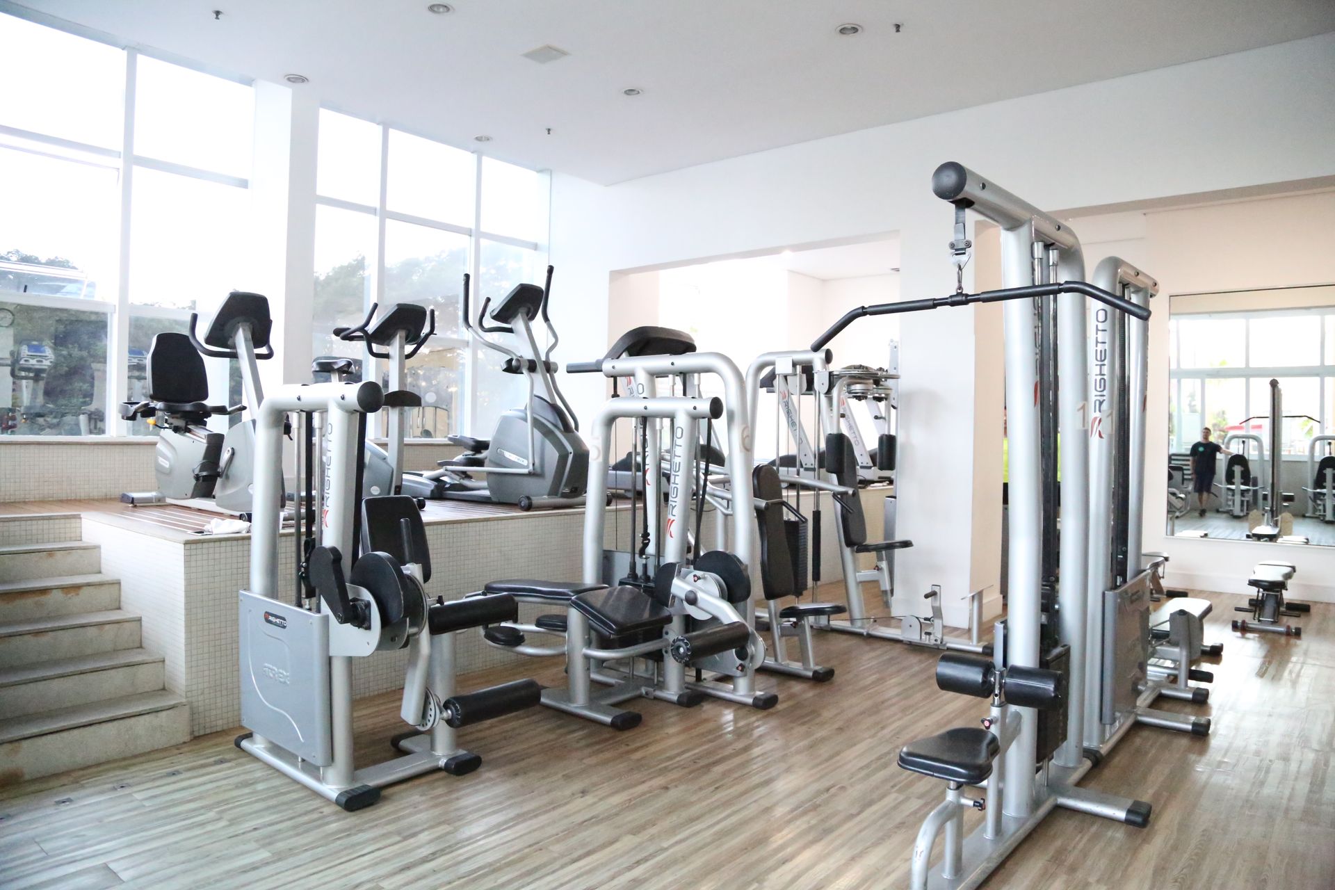 Uma academia cheia de equipamentos de exercícios e escadas.