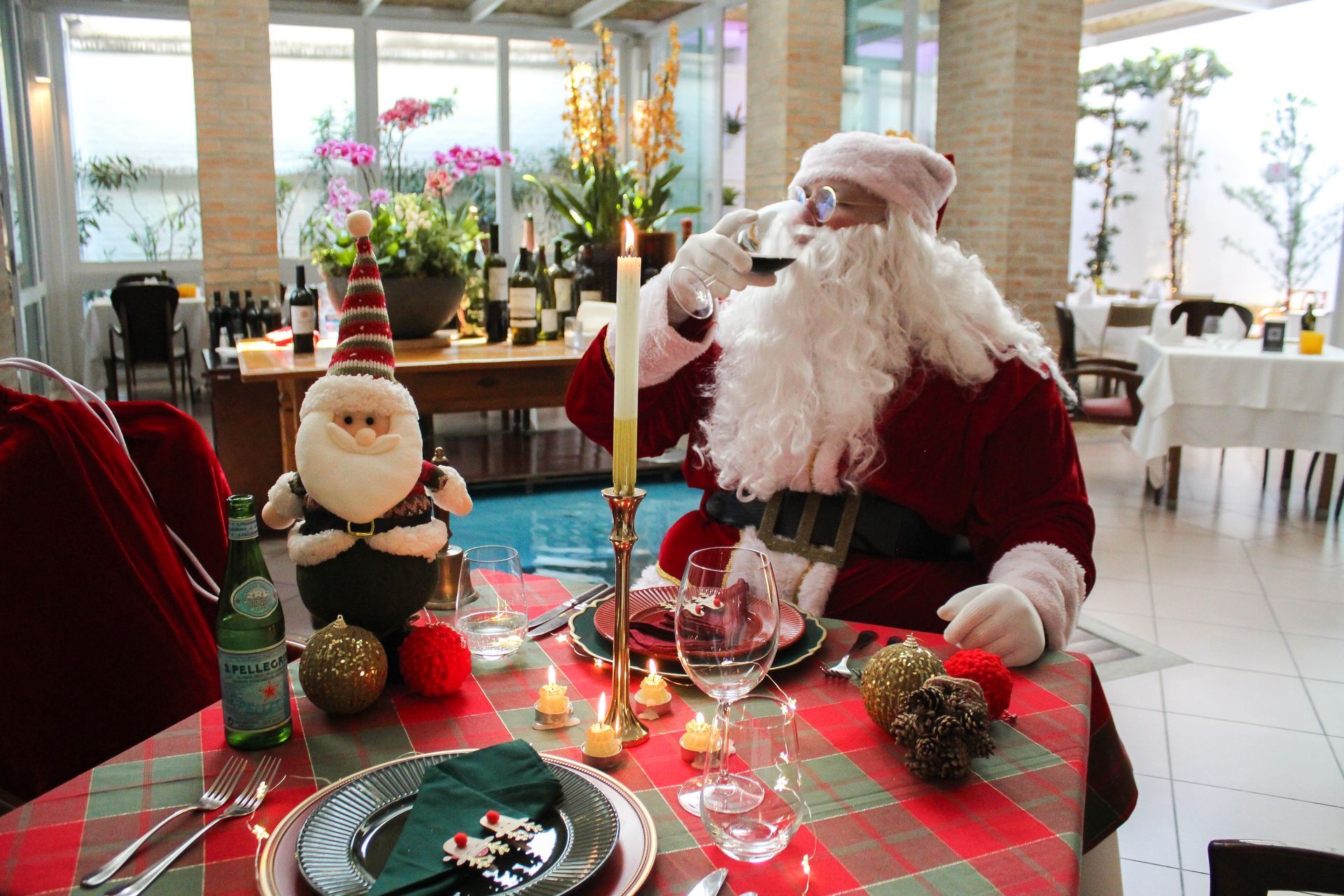 Papai noel está sentado à mesa em um restaurante