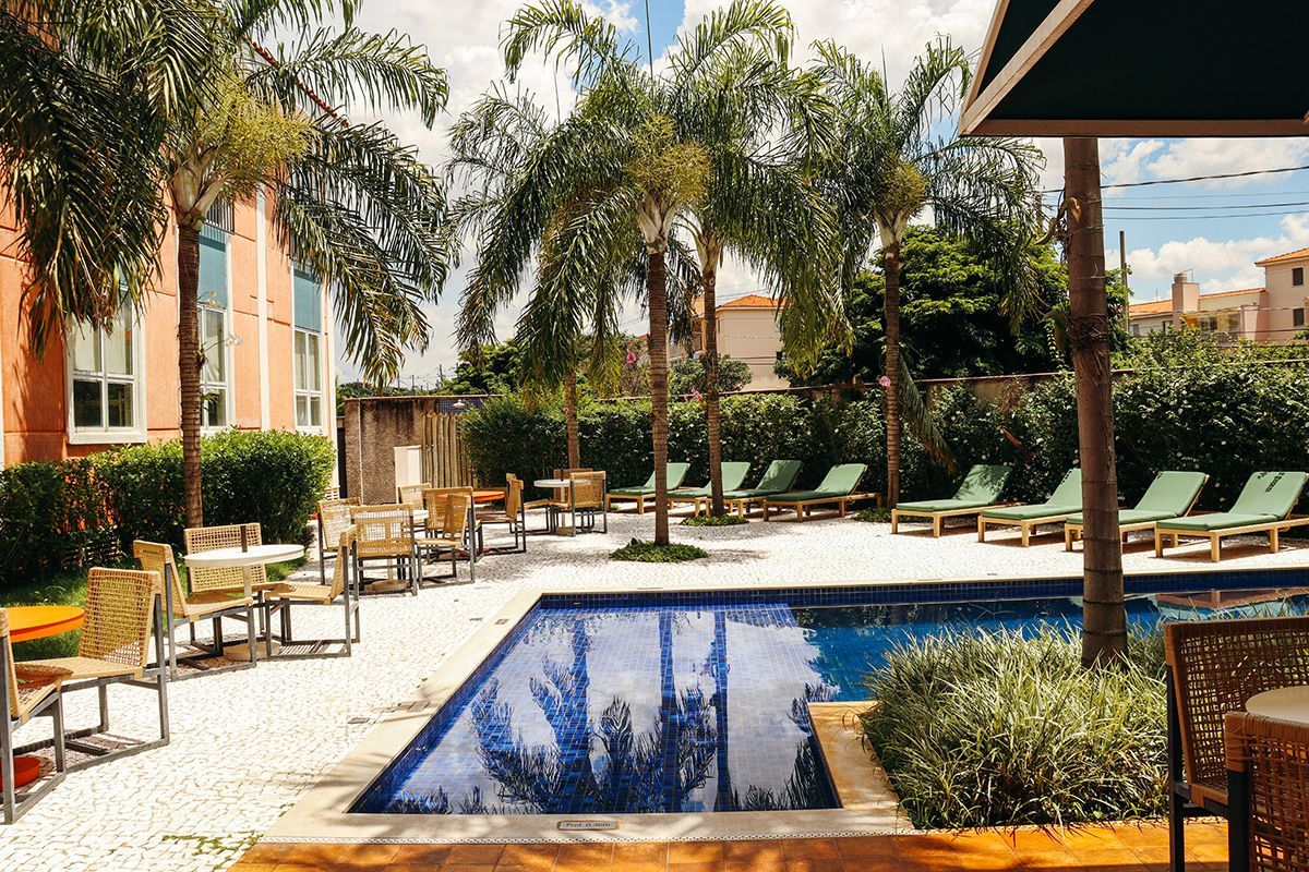 Uma grande piscina rodeada por cadeiras e mesas.