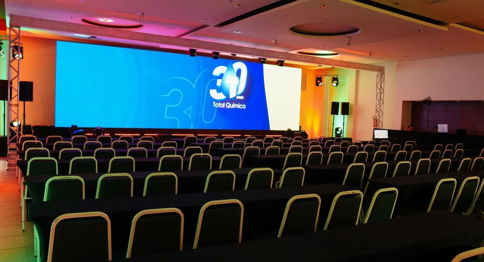 Uma sala grande com mesas e cadeiras e uma tela grande com o número 30 nela.