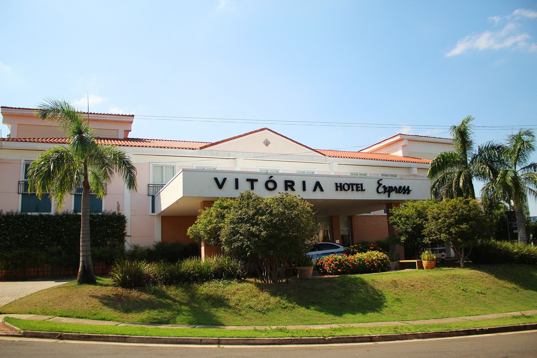 Um hotel chamado vitória é cercado por palmeiras