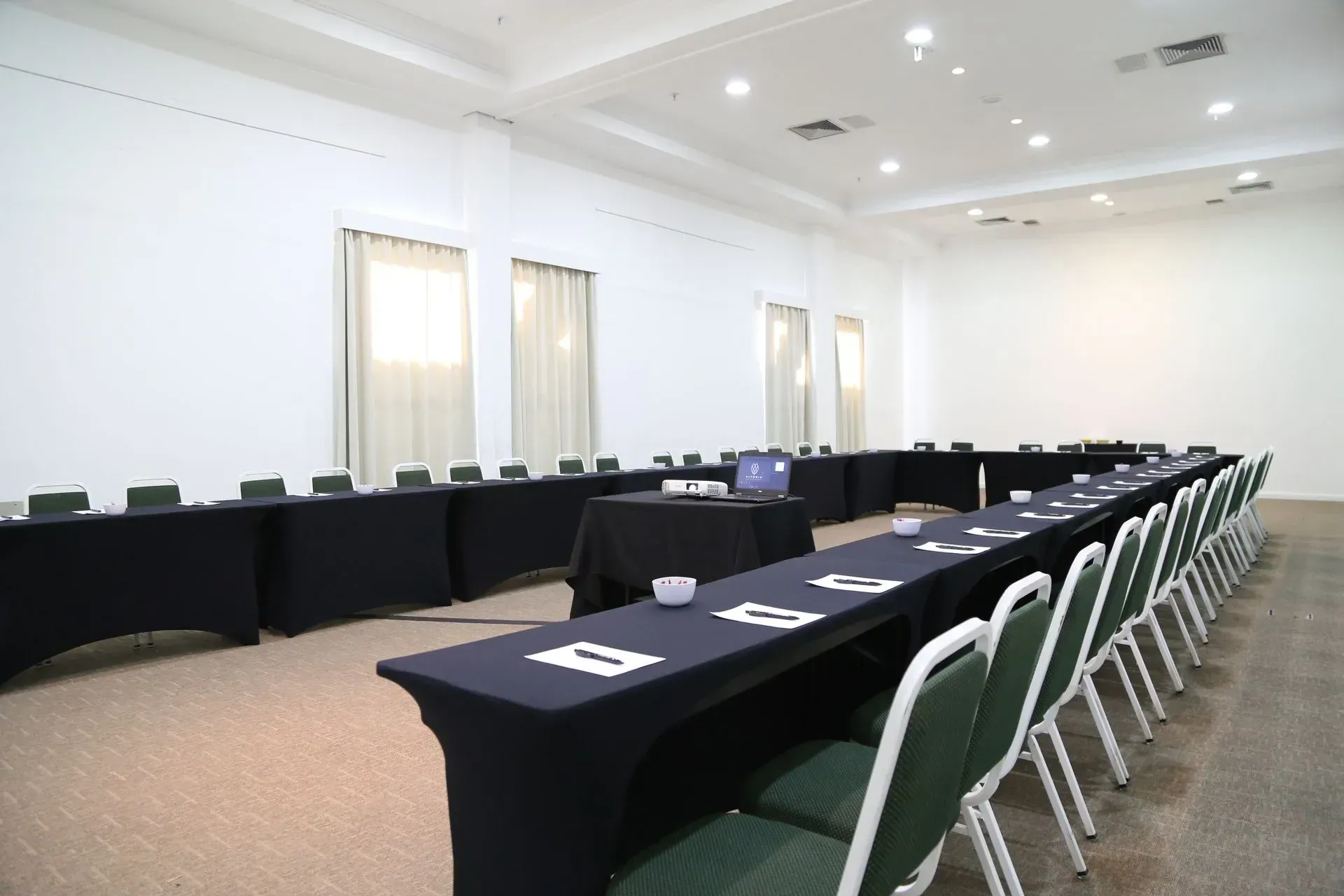 Uma sala de conferências com mesas e cadeiras preparadas para uma reunião