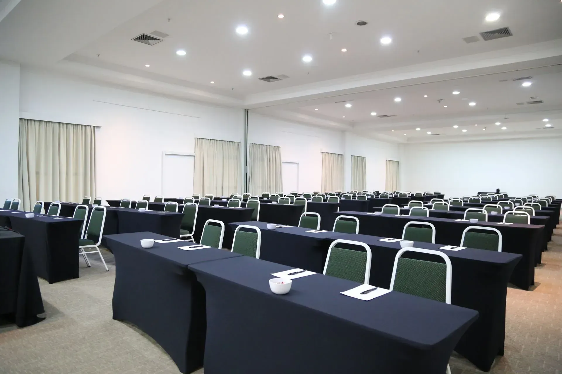 Uma sala grande com fileiras de mesas e cadeiras