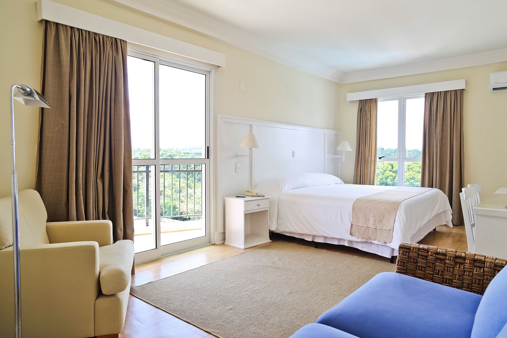 Um quarto de hotel com uma cama grande e um sofá azul