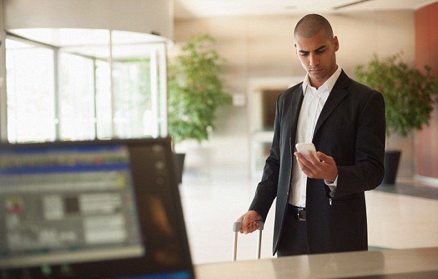 Um homem segurando o celular para fazer check-in no hotel