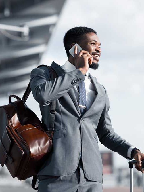 homem segurando celular e mochila