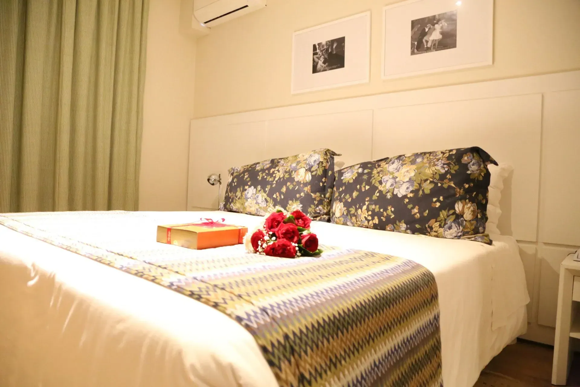 uma cama de hotel com um buquê de rosas em cima da cama